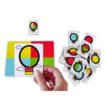 Jogo Balão Colorido da Materiais para Brincar, mostrando uma placa de madeira com um balão vazado posicionado sobre uma superfície colorida, formando uma combinação de cores.