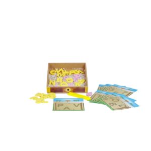 Jogo Baú do Tesouro da Materiais para Brincar, mostrando um baú de madeira aberto com pérolas douradas e peças de letras e números. Uma pinça está sendo usada para pegar uma das peças.