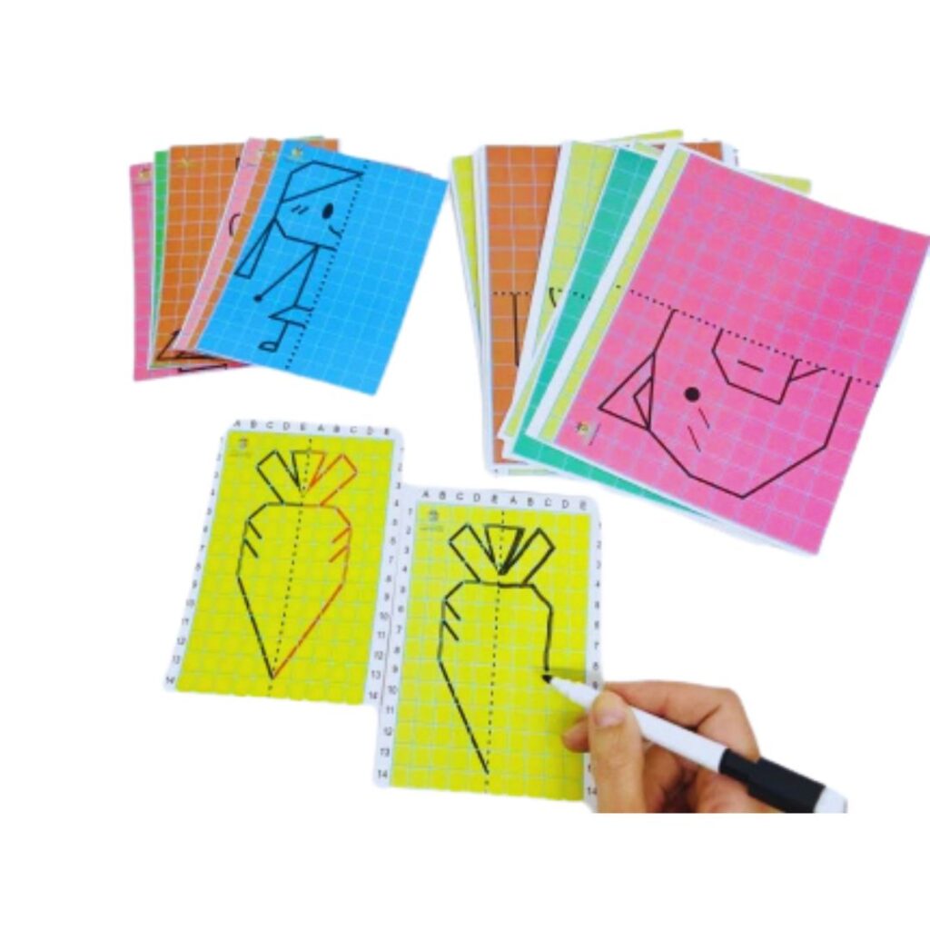 Kit Desenhos Simétricos da Materiais Para Brincar, mostrando uma das fichas com metade de um desenho. Uma mão de criança está usando uma caneta para completar a outra metade de forma simétrica.