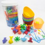 Kit Montessori Fundo do Mar da Materiais para Brincar, com potes coloridos, pinça e miniaturas de animais marinhos.