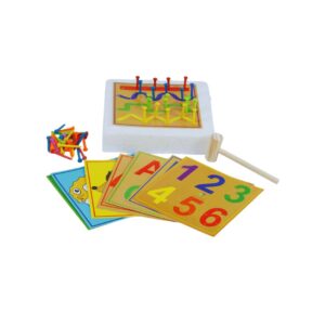 O jogo Martelando da Materiais Para Brincar, mostrando uma mão de criança usando um martelo de madeira para inserir um preguinho colorido em uma das fichas perfuradas, que está sobre uma placa de isopor.